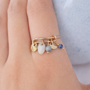 Bague ajustable jaspe bleu et nacre Alizée avec pendants dorés portée à la main