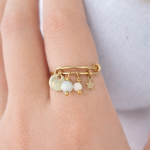 Bague amazonite et nacre Elsa portée à la main avec médaille dorée et étoile