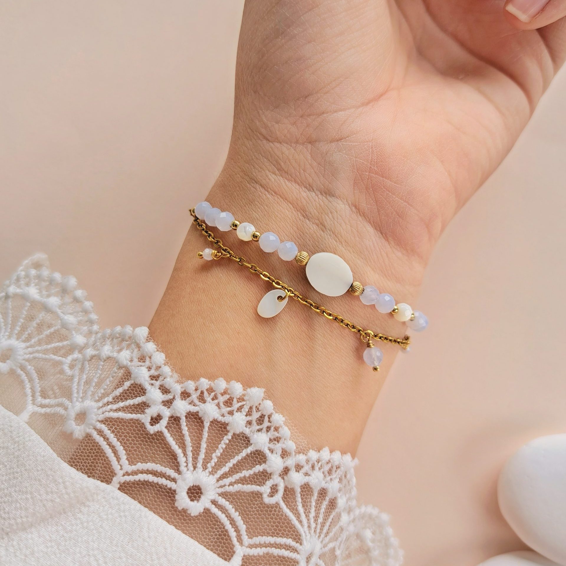 Bracelet double rang calcédoine Nola porté sur l’intérieur du poignet avec nacre et détails dorés