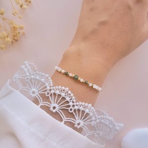 Bracelet Anna en agate mousse et nacre porté au poignet avec détails dorés