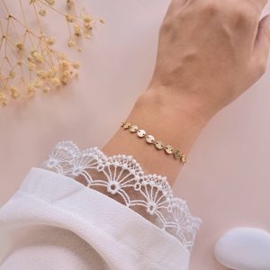 Bracelet doré en plaqué or Alba porté au poignet avec disques ronds texturés