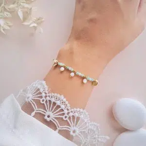 Bracelet amazonite à breloques Théa porté au poignet avec perles pendantes en nacre et détails dorés