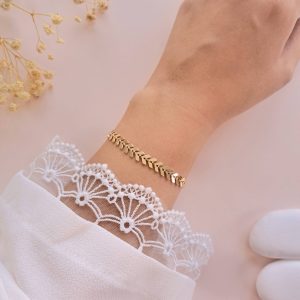 Bracelet chevron doré Marva porté au poignet en laiton doré avec motif graphique