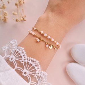 Bracelet Elena double rang rose et doré porté au poignet avec opale rose, nacre et pampilles