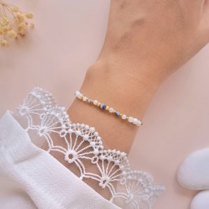 Bracelet en nacre et jaspe bleu Billie porté au poignet avec détails dorés