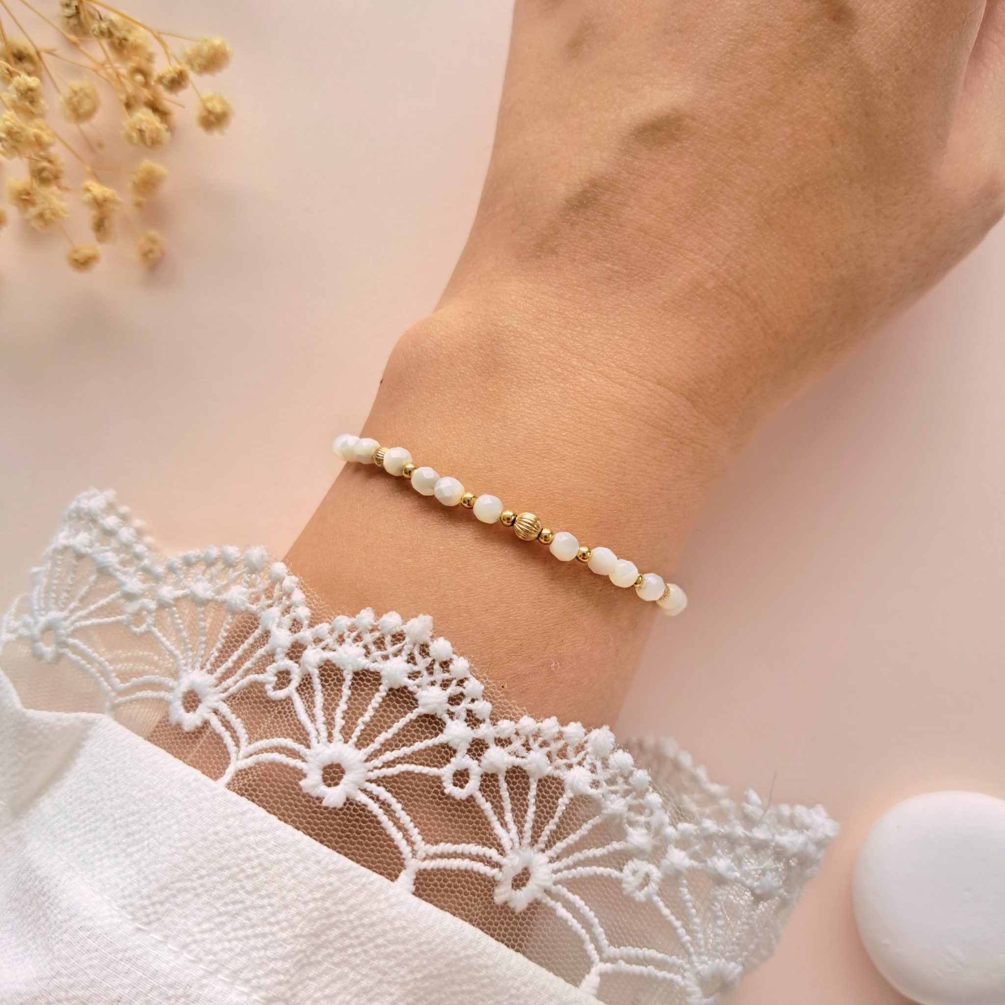 Bracelet fin nacre Gabrielle n°1 porté au poignet avec perle centrale dorée