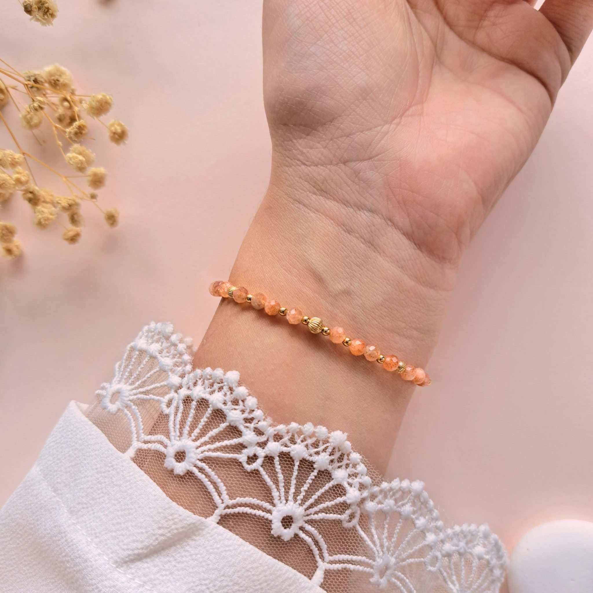 Bracelet fin pierre de soleil Eva n°1 porté sur l’intérieur du poignet avec détails dorés