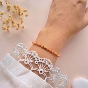 Bracelet fin pierre de soleil Eva n°1 porté au poignet avec détails dorés