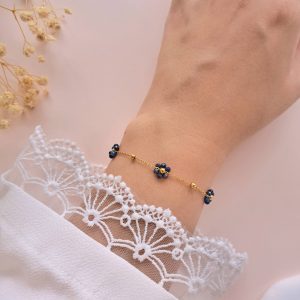 Bracelet fleurs en lapis lazuli Mila porté au poignet avec chaîne dorée