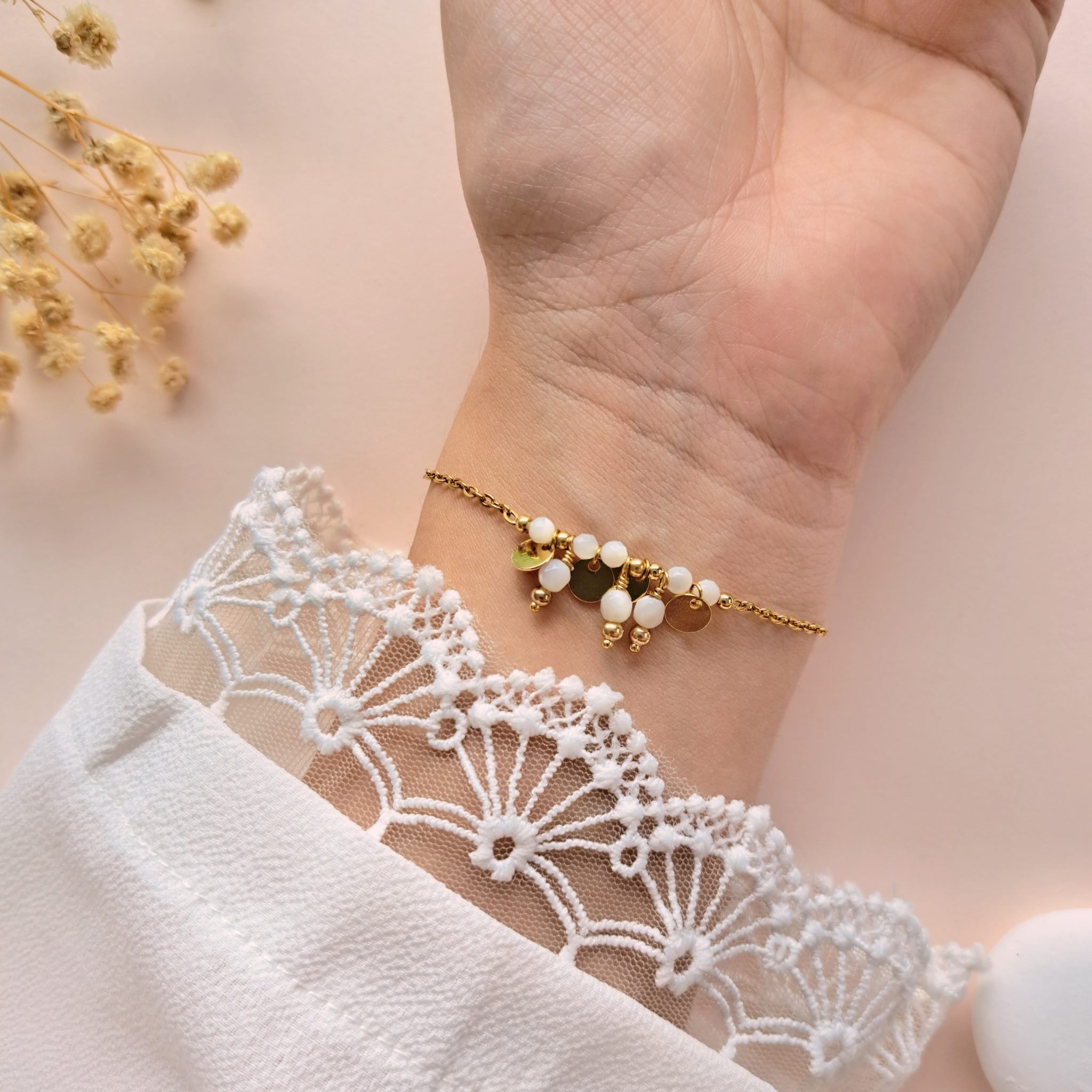 Bracelet nacre à breloques Gabrielle n°3 porté sur l’intérieur du poignet avec breloques rondes en cuivre doré