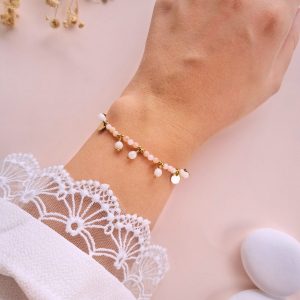 Bracelet Ariane en opale rose et nacre porté au poignet avec pampilles et médailles dorées