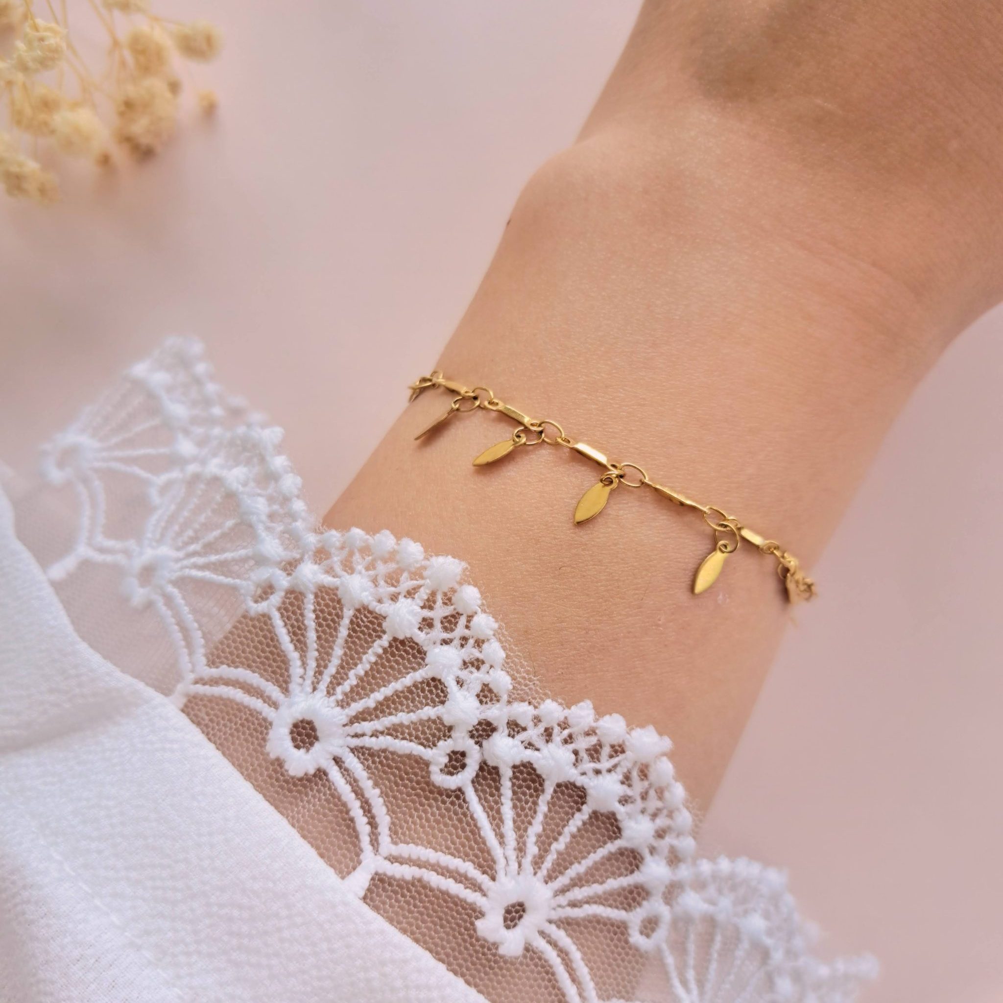 Bracelet pampilles acier inoxydable Sienna en détail au poignet avec pampilles dorées allongées