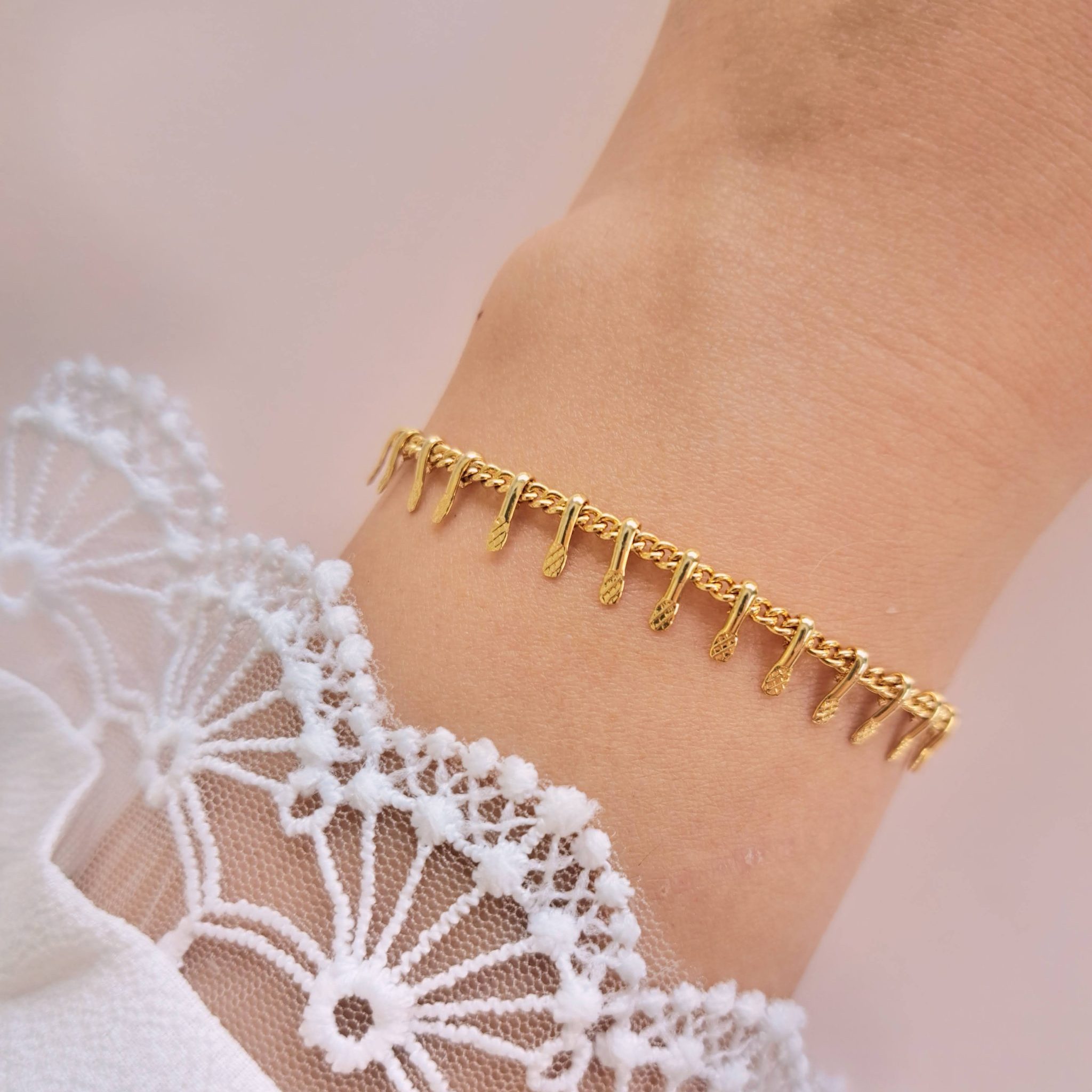 Bracelet pampilles dorées Tia en détail au poignet avec fines pampilles en acier inoxydable