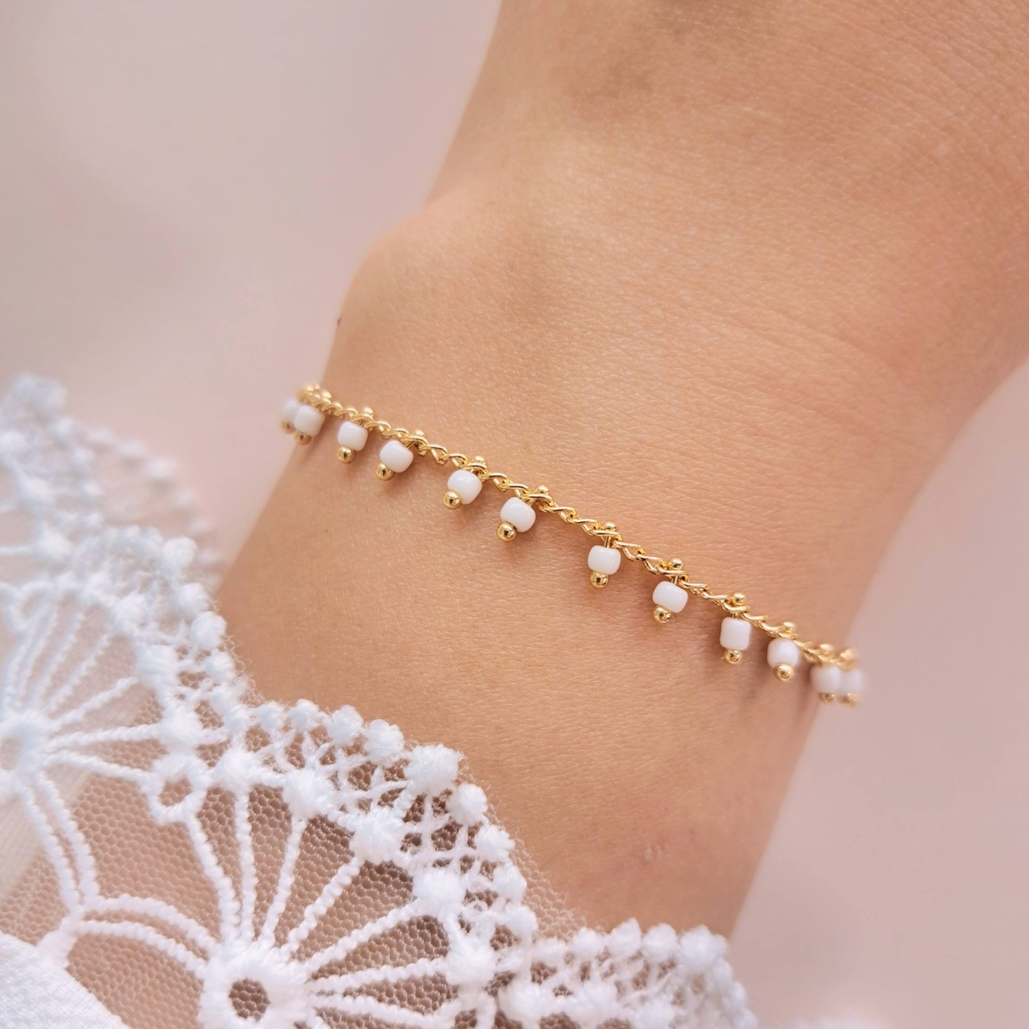 Bracelet perles blanches acier inoxydable Lily en détail au poignet avec petites perles blanches pendantes