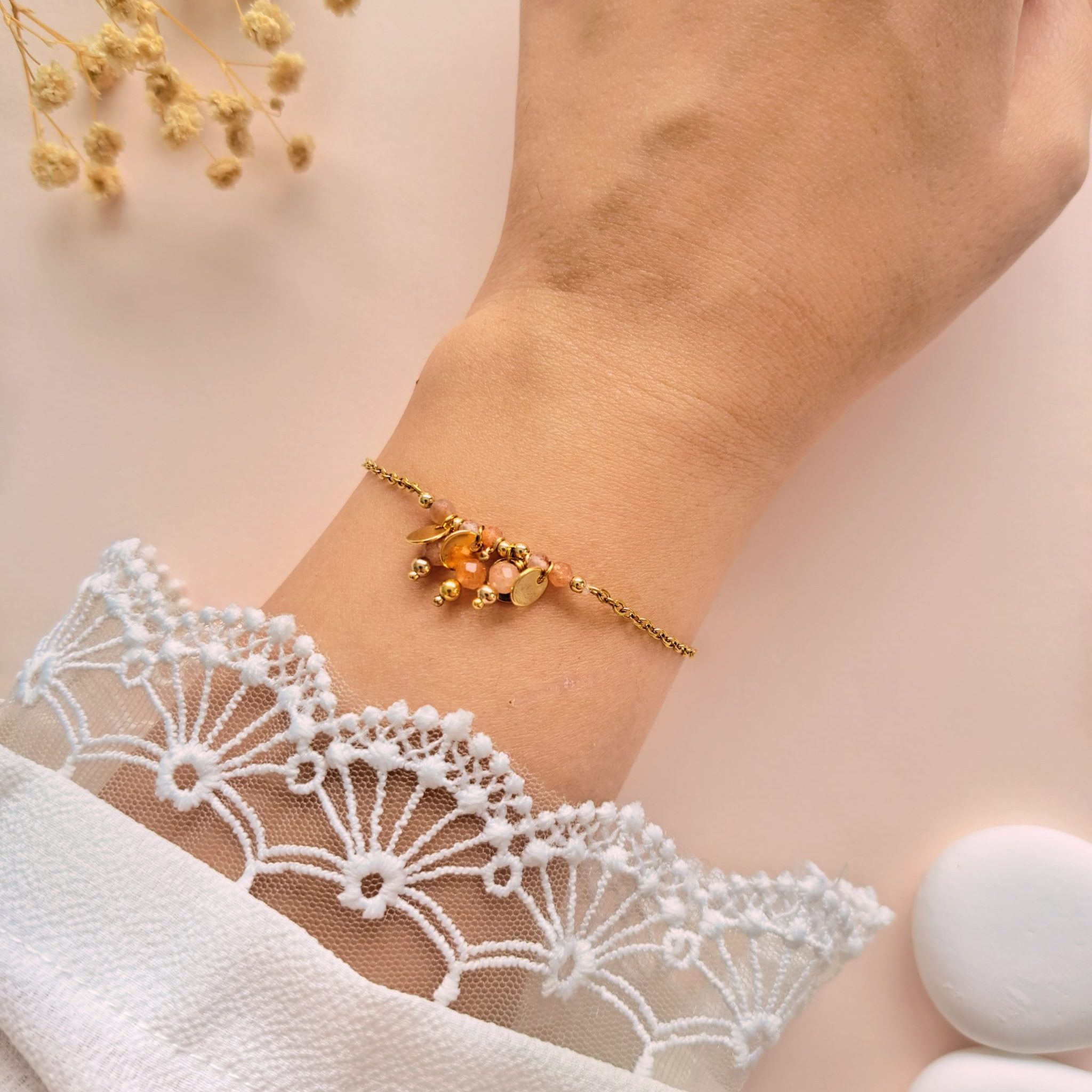 Bracelet pierre de soleil à breloques Eva n°3 porté au poignet avec breloques rondes en cuivre doré