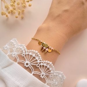 Bracelet Lina n°3 rose à breloques dorées porté au poignet avec perles d’opale rose