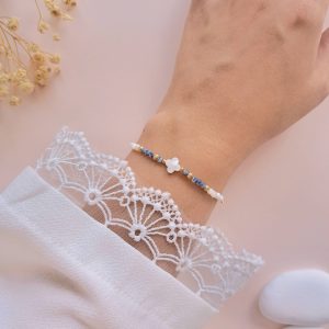 Bracelet trèfle en nacre et jaspe bleu Joy porté au poignet avec détails dorés