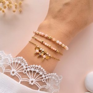 Ensemble de trois bracelets en opale rose Trio Lina porté au poignet avec détails et breloques dorés