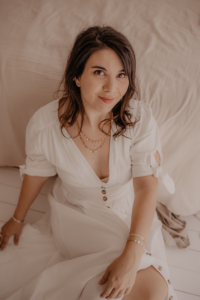 Femme portant une robe blanche avec des bijoux dorés Soleva au cou et au poignet