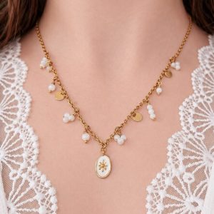 Collier doré à breloques en nacre Pauline porté avec pendentif central et détails dorés