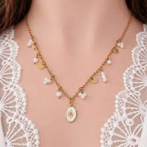 Collier doré à breloques en nacre Pauline porté avec pendentif central et détails dorés