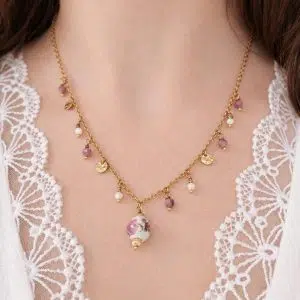 Collier tourmaline rose et nacre Soraya porté avec pendentif floral et détails dorés
